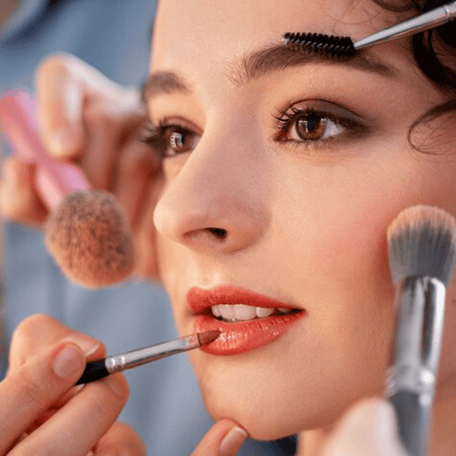 Maquiagem sendo aplicada em mulher com precisão e cuidado.